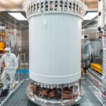 The LUX-ZEPLIN main dark matter detector, a large cylindrical tank, pictured in a surface lab before its installation nearly a mile underground at the Sanford Underground Research Facility
